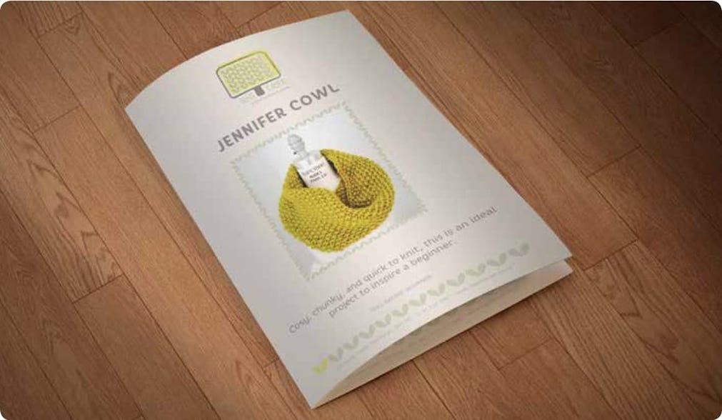 A Pamphlet for Big Tree knitting supplies is sitting on a wooden floor