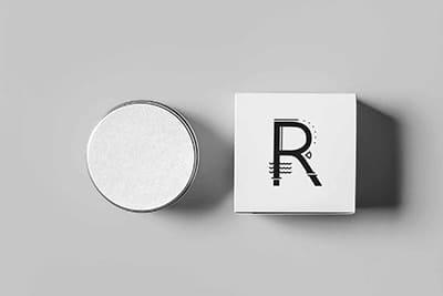 Packaging for Ritual Makeup products in balack and white on a grey background, viewed from the top