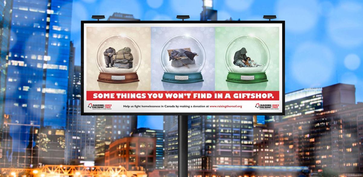 Billboard for homeless awareness featuring snowglobes in front of a busy city