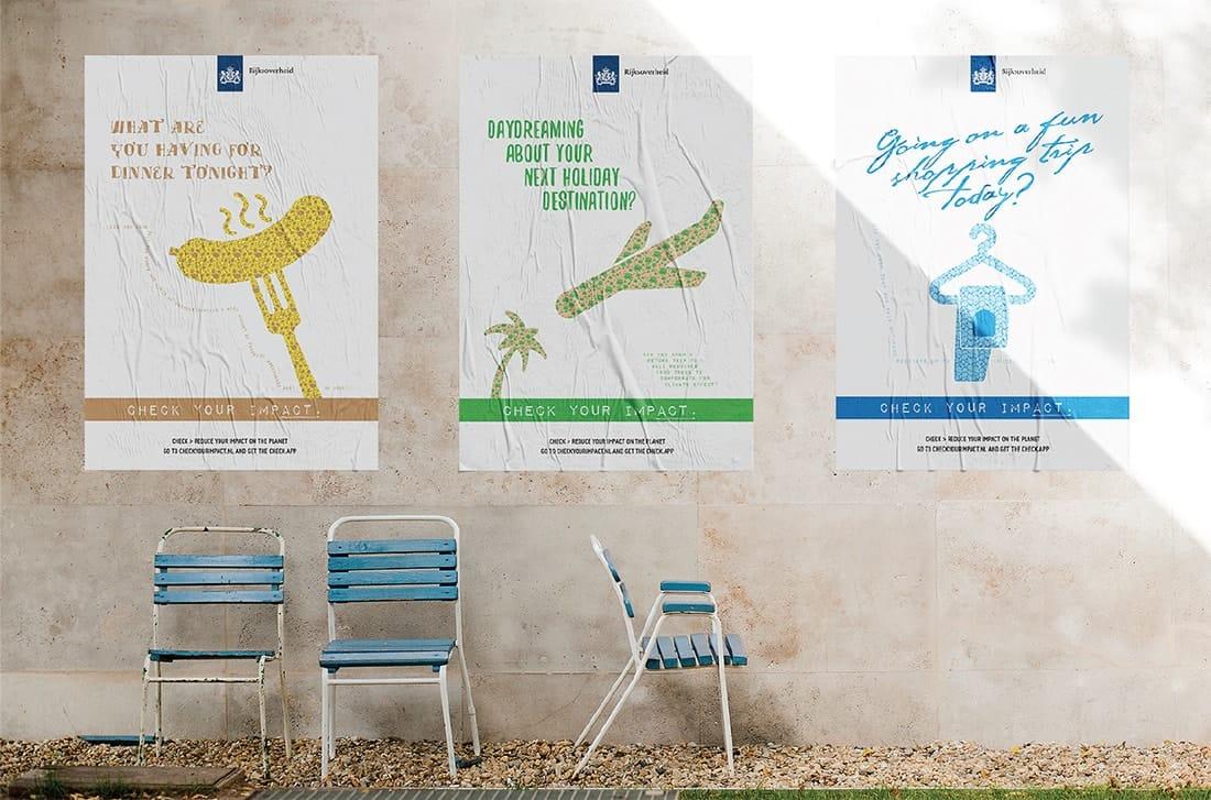 Three posters aligned on a cement wall with three metal chairs underneath them